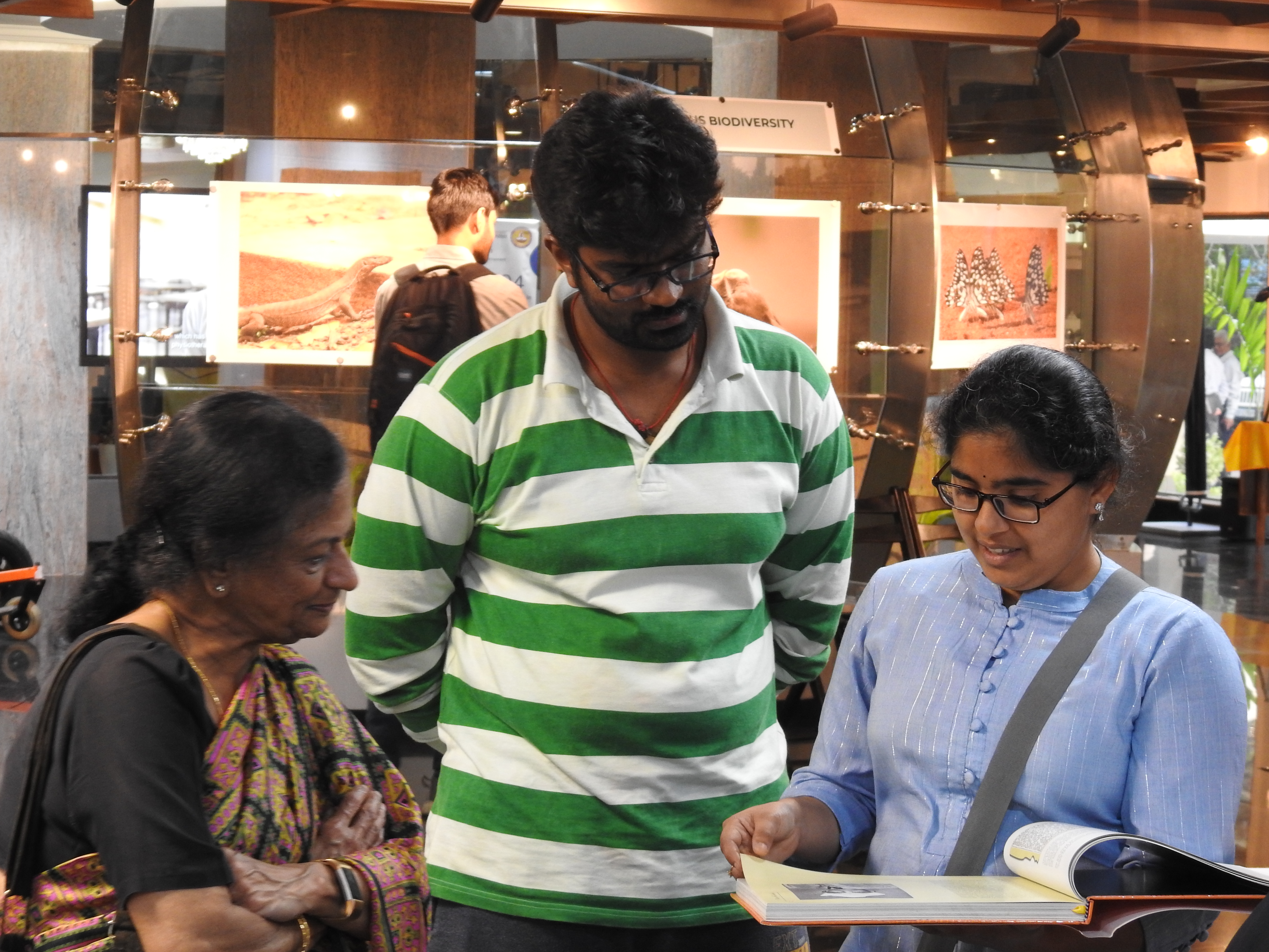 Mrs. Padma and other visitors flip through the Campaschimes coffee table book 