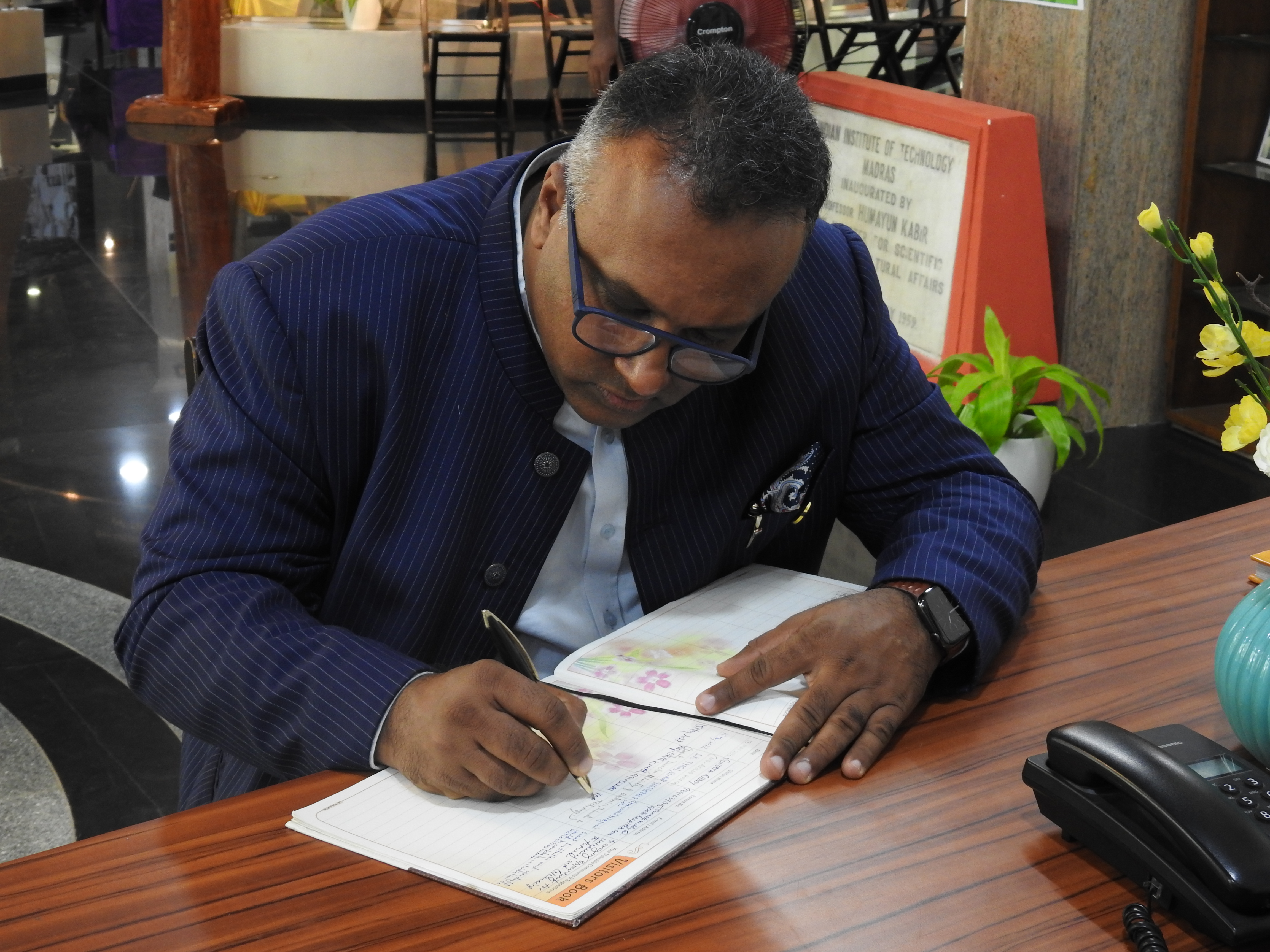 Prof. Dr. C. Raj Kumar writes in the visitor's book at the Heritage Centre