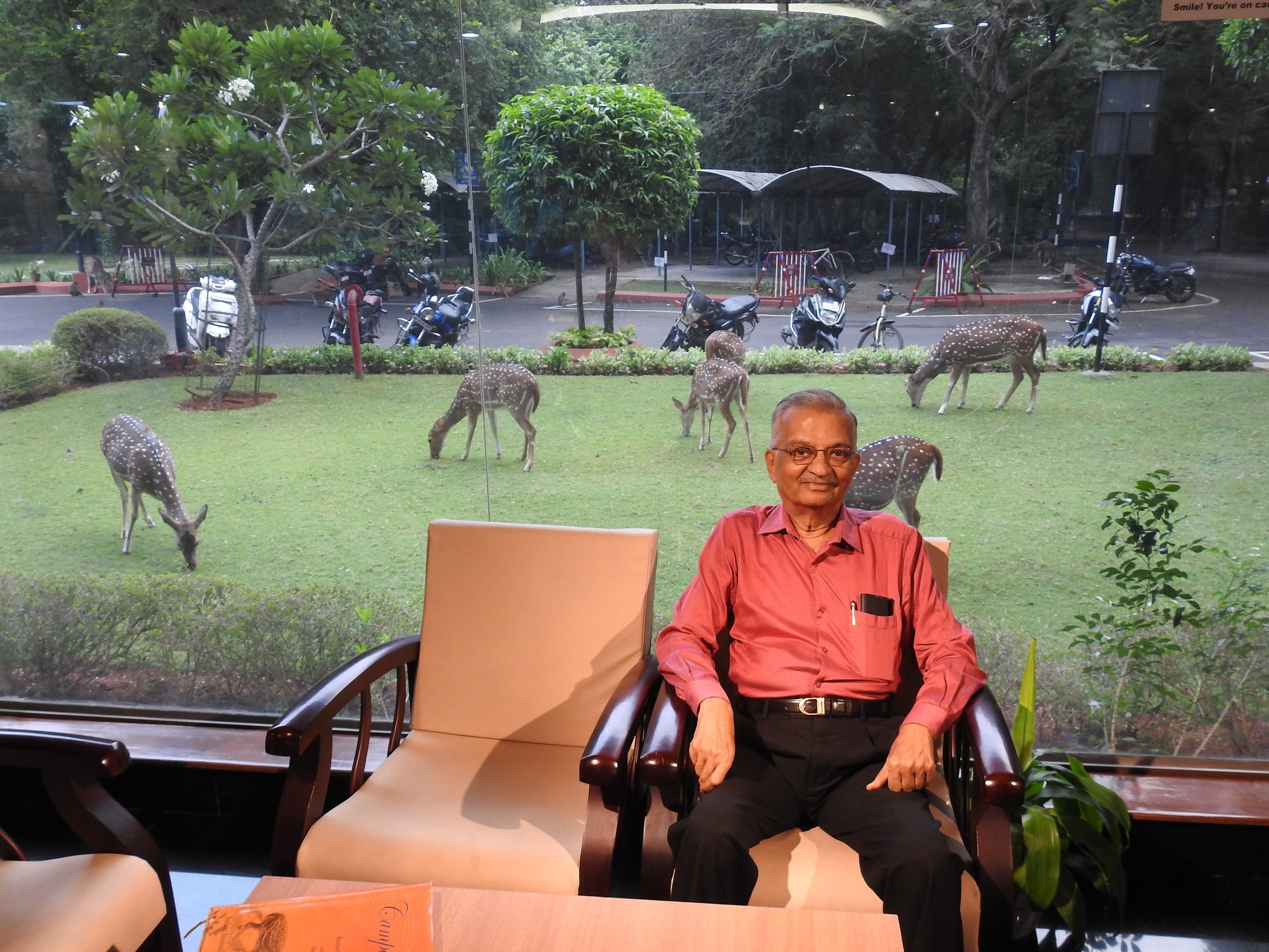 Dr. Anil Kakodkar at the Reading Area with spotted deer in the background 