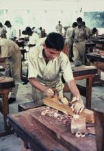 A student planing at the carpentry workshop