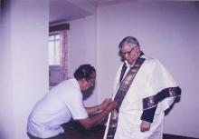 The chief guest, Mr. Jamshed J. Irani is assisted while adorning the convocation robes