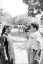 A nun conversing with an individual during Mardi Gras, 1983