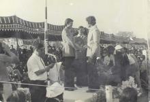 A competition winner is congratulated on the podium