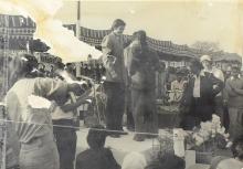 A competition winner is congratulated on the podium