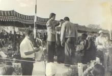 A competition winner is congratulated on the podium