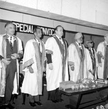 The distinguished guests stand on the dais during the invocation (possibly)