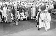 Dr. A.L. Mudaliar escorts Sir C.V. Raman to the dias as the audience stands and watches on with respect