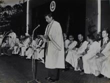 Mr. R. Natarajan and Prof. B. Sengupto standing at the microphones while faculty members and distinguished guests are seated behind them, 1965