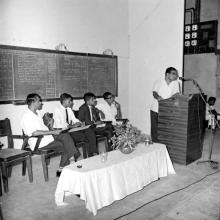 A person addresses a gathering as Prof. R. G. Narayanamurthi and a few students look on, 1968