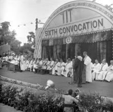 A student walks onto the dais to receive his degree