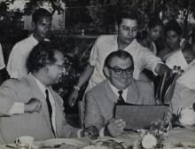 Prof. B. Sengupto and Mr. Hans Lenz discuss the images in a photo album while Mr. Dubey assists in flipping the pages