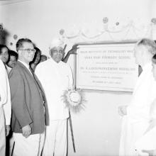 Administrators photographed next to the foundation stone of Vanavani School