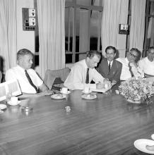 Mr. J. R. D. Tata signs the autograph book as some members of the faculty look on, 1969