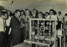 The panel members of the Valedictory function for the Short Term Course in High Vacuum Technology examine and discuss the demonstration of a glass sphere being evacuated at the event
