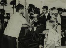 Mrs. Ann Lohmann Fischer gives away a trophy to a student at the first Inter-Collegiate Sports Meet, 1964