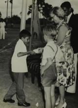 Mrs. Ann Lohmann Fischer gives away a prize to a young boy at the first Inter-Collegiate Sports Meet, 1964
