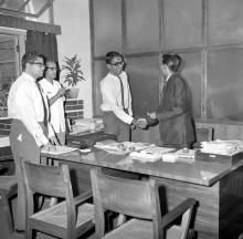 A student hands over a collection to support the Koyna earthquake victims to Prof. A. Ramachandran, Director, as Prof. S. Sampath, Deputy Director and Mr. C. V. Sethunathan, Registrar, look on, 1968 