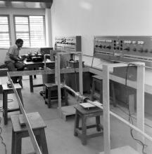 A professor or laboratory staff operating equipment at the Electrical Engineering Laboratory