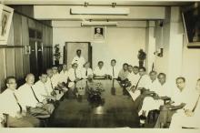 A photograph of faculty members of the Institute gathered at a meeting