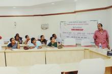 A speaker addresses a gathering at the 4th Hindi Workshop