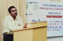 A speaker addresses a gathering at the 4th Hindi Workshop