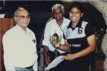 A member of the M.O.P. Vaishnav College for Women's basketball team with a trophy, 2005