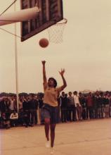 A girl takes a lay up during a basketball match, 1985