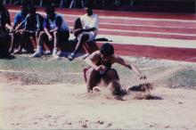 An athlete lands in the landing pit at a jump event, 1999