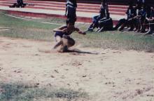 A student lands in the landing pit during a jump event, 1999