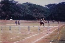 A hurdler leaps over a hurdle during a race, 1999