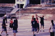 A basketball player swats a ball away during a match, 1999