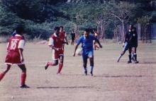 Players attack the ball during a football match, 1999