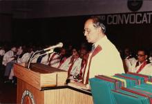 Degree certificates seen to the right of the Director as he addresses the audience 
