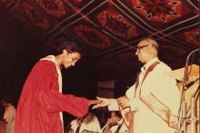 A student receives her degree from the Director, 1983
