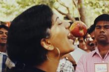A participant attempts to bite an apple, 2003