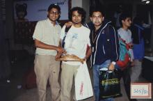 A trio poses for a photograph with a trophy, 2003