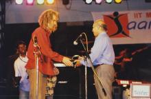 After a musical performance, a member of the band is congratulated and handed a memento by a member of the IITM administration at Saarang 2003