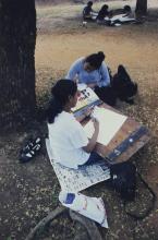 Participants of the art competition paint under a tree