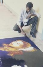 A participant poses with his rangoli art at a rangoli competition that was held during the Saarang 2000 cultural festival